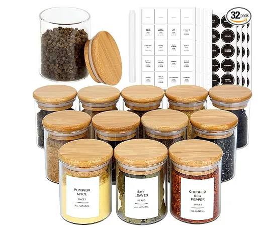 Set of clear spice jars with bamboo lids and printed labels.