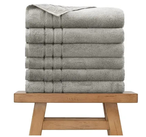 Stack of folded gray towels on a wooden stool.