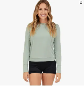 Woman modeling a pale green long-sleeve crew-neck shirt.