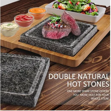 Sliced steak cooking on a hot stone set into a bamboo serving board.